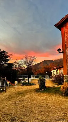 a kite flying in front of a house with a sunset at Cabañas Maranatha in El Rincón