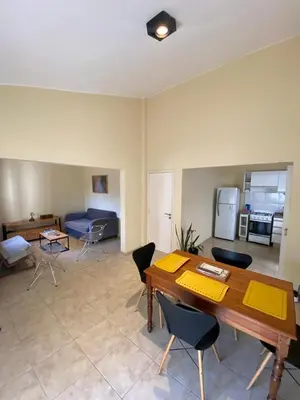 a living room with a wooden table and chairs at Departamento PARQUE Velez Sarsfield, zona sur - Cordoba capital in Cordoba