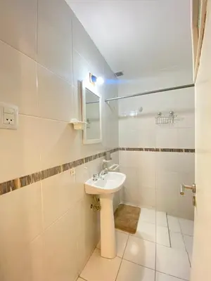 a white bathroom with a sink and a mirror at Departamento PARQUE Velez Sarsfield, zona sur - Cordoba capital in Cordoba
