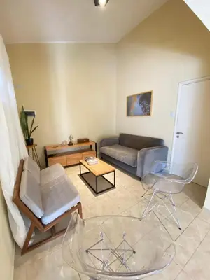 a living room with a couch and a glass table at Departamento PARQUE Velez Sarsfield, zona sur - Cordoba capital in Cordoba