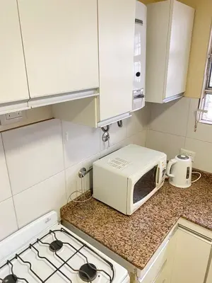 a microwave oven sitting on a counter in a kitchen at Departamento PARQUE Velez Sarsfield, zona sur - Cordoba capital in Cordoba