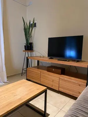 a living room with a flat screen tv on a wooden stand at Departamento PARQUE Velez Sarsfield, zona sur - Cordoba capital in Cordoba