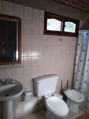 a bathroom with a toilet and a sink at Estancia La Victoria - Cabañas de Montaña in Villa Yacanto