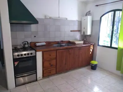 a kitchen with a sink and a stove at Estancia La Victoria - Cabañas de Montaña in Villa Yacanto