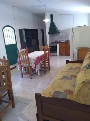 a kitchen with a table and chairs in a room at Estancia La Victoria - Cabañas de Montaña in Villa Yacanto