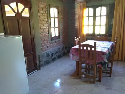 a kitchen with a table and chairs in a room at Estancia La Victoria - Cabañas de Montaña in Villa Yacanto