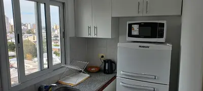a kitchen with a microwave on top of a refrigerator at Cómodo Dpto Colón 600 in Río Cuarto