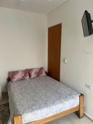 a small bedroom with a bed and a tv at studios in Cordoba in Cordoba