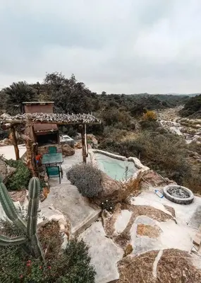 a backyard with a swimming pool and a cactus at Cueva de lujo con rio de montaña Casa cueva in Villa Cura Brochero