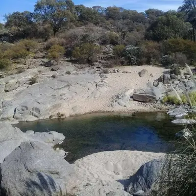 a small pool of water in a rocky field at Cueva de lujo con rio de montaña Casa cueva in Villa Cura Brochero
