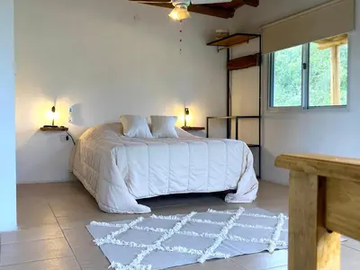 a bedroom with a large bed with a white comforter at Cabañas Yin y Yang in Pueblito