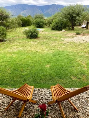 two wooden benches sitting on a rocky ground with a field at Cabañas Yin y Yang in Pueblito