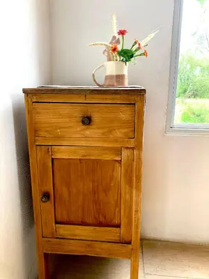 a wooden cabinet with a vase of flowers on it at Cabañas Yin y Yang in Pueblito