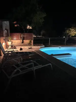a swimming pool at night with two chairs next to it at Casa Campo Cordoba Cabalango in Cavalango