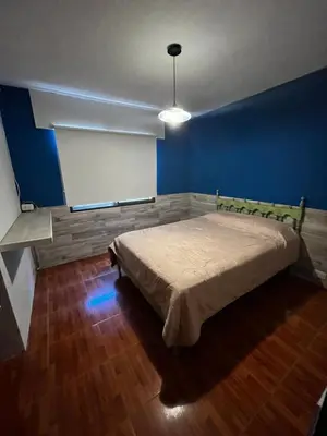 a bedroom with a bed with a blue wall at Casa Campo Cordoba Cabalango in Cavalango