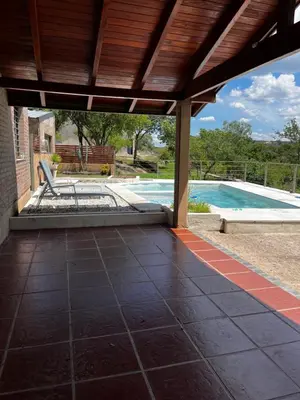 an outdoor patio with a pool and a wooden roof at Casa Campo Cordoba Cabalango in Cavalango