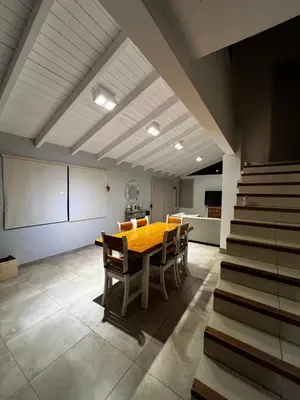 a dining room with a wooden table and chairs at Casa Campo Cordoba Cabalango in Cavalango