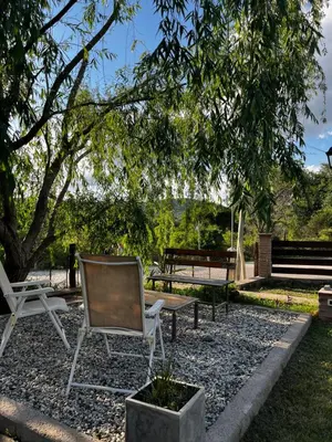 a chair and a bench sitting under a tree at Casa Campo Cordoba Cabalango in Cavalango