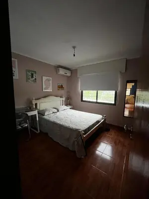 a bedroom with a bed and a desk and a window at Casa Campo Cordoba Cabalango in Cavalango