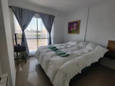 a large bed in a bedroom with a window at Departamento Lautaro III Alta Cordoba Cofico in Cordoba