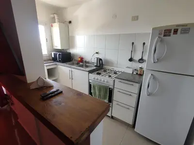 a kitchen with a white refrigerator and a wooden counter at Departamento Lautaro III Alta Cordoba Cofico in Cordoba