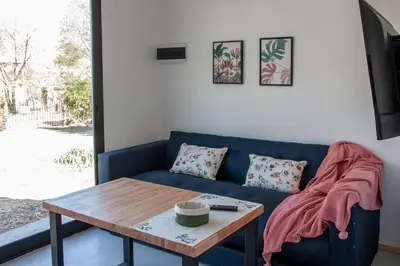 a living room with a blue couch and a table at Minicasas cerca del rio Los Reartes in Villa Ciudad Parque