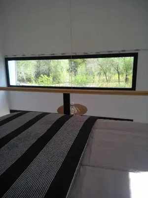 a bedroom with a window with a bed in front of it at Minicasas cerca del rio Los Reartes in Villa Ciudad Parque