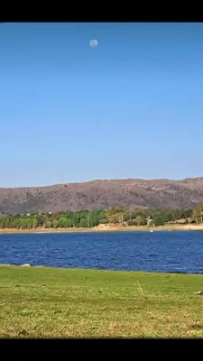 a view of a body of water with a grass field at Minicasas cerca del rio Los Reartes in Villa Ciudad Parque