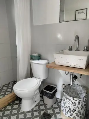 a bathroom with a toilet and a sink at Minicasas cerca del rio Los Reartes in Villa Ciudad Parque