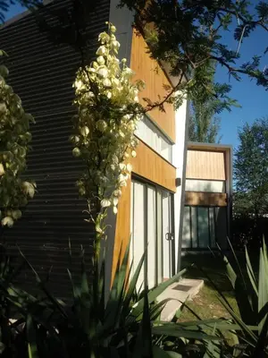 a building with a door and a bunch of flowers at Minicasas cerca del rio Los Reartes in Villa Ciudad Parque