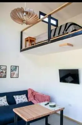 a living room with a blue couch and a wooden table at Minicasas cerca del rio Los Reartes in Villa Ciudad Parque
