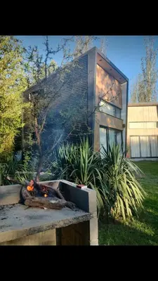 a fire in a fire pit in front of a house at Minicasas cerca del rio Los Reartes in Villa Ciudad Parque