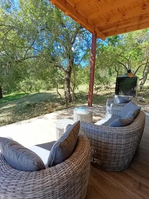 a patio with two wicker chairs under a pergola at Cabaña VenTeVeo Chakra de Montaña in Atos Pampa