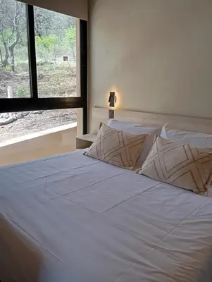 a bedroom with a white bed with a window at Cabaña VenTeVeo Chakra de Montaña in Atos Pampa