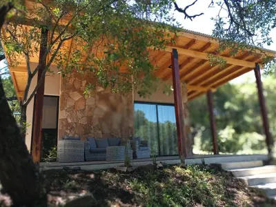 a house with a sitting area in front of it at Cabaña VenTeVeo Chakra de Montaña in Atos Pampa