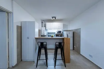 a kitchen with two bar stools and a counter top at Viaggiato Felix Frías in Cordoba