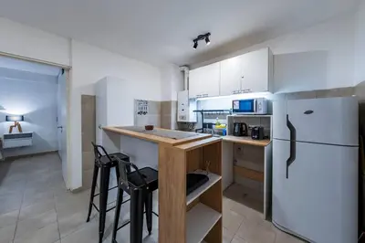 a kitchen with a white refrigerator and a counter with stools at Viaggiato Felix Frías in Cordoba
