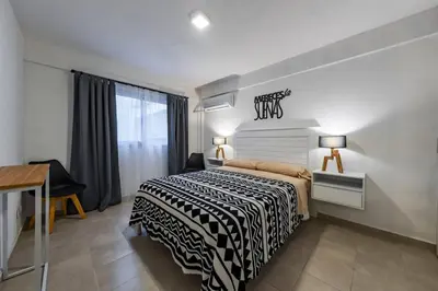 a bedroom with a black and white bed and a desk at Viaggiato Felix Frías in Cordoba