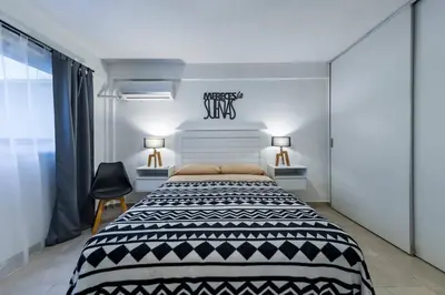 a bedroom with a black and white bed and two lamps at Viaggiato Felix Frías in Cordoba