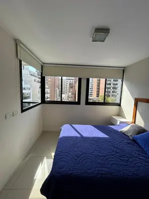 a bedroom with a blue bed and two windows at Departamento -Peredo- 2 cuadras de plaza España-Cuidad universitaria By Apartcba in Cordoba