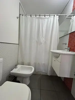 a white bathroom with a toilet and a sink at Departamento -Peredo- 2 cuadras de plaza España-Cuidad universitaria By Apartcba in Cordoba