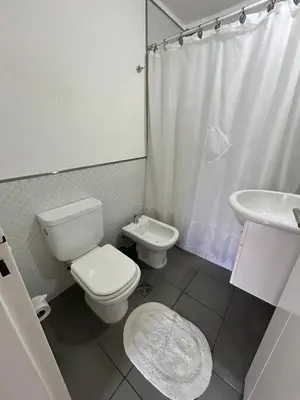 a white bathroom with a toilet and a sink at Departamento -Peredo- 2 cuadras de plaza España-Cuidad universitaria By Apartcba in Cordoba