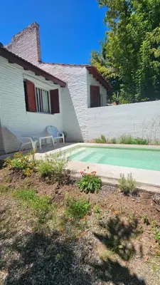 a house with a yard with a green tennis court at CASA TILO con pileta exclusiva in Mina Clavero