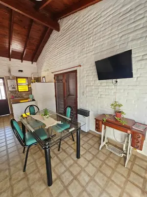 a living room with a table and chairs and a tv at CASA TILO con pileta exclusiva in Mina Clavero