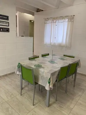 a table with green chairs in a room at Casa Playas De Oro in Villa Independencia
