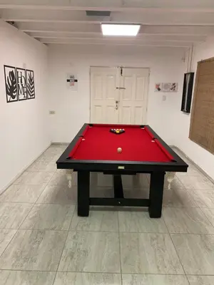 a ping pong table in a room with a red cloth at Casa Playas De Oro in Villa Independencia