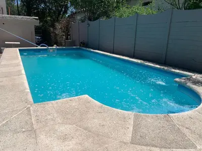 a swimming pool with blue water in a backyard at Casa Playas De Oro in Villa Independencia