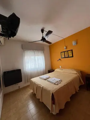 a bedroom with a bed and a flat screen tv at Hotel Grisabel in Villa Carlos Paz