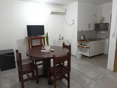 a kitchen with a table with chairs and a television at Altos de Horizonte I in Cordoba