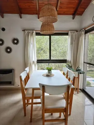 a dining room with a white table and chairs at Flusshaus8 in Villa General Belgrano